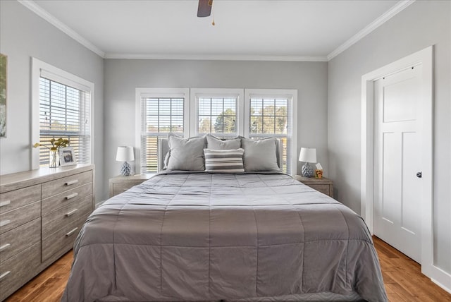 bedroom featuring crown molding, hardwood / wood-style flooring, and ceiling fan