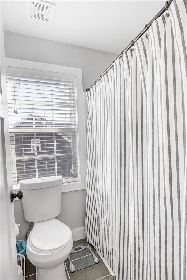 bathroom with toilet and a shower with curtain