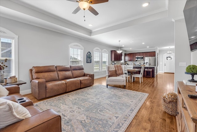 living room with crown molding, light hardwood / wood-style flooring, and ceiling fan