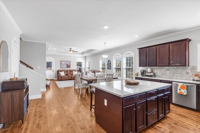 kitchen featuring a center island, ceiling fan, decorative light fixtures, crown molding, and light hardwood / wood-style flooring