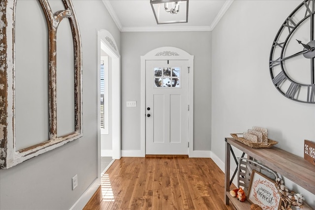 entrance foyer featuring crown molding and light wood-type flooring