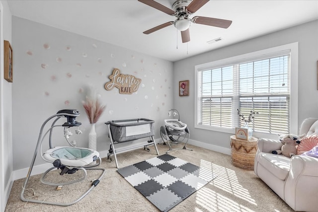 living area featuring light colored carpet and ceiling fan