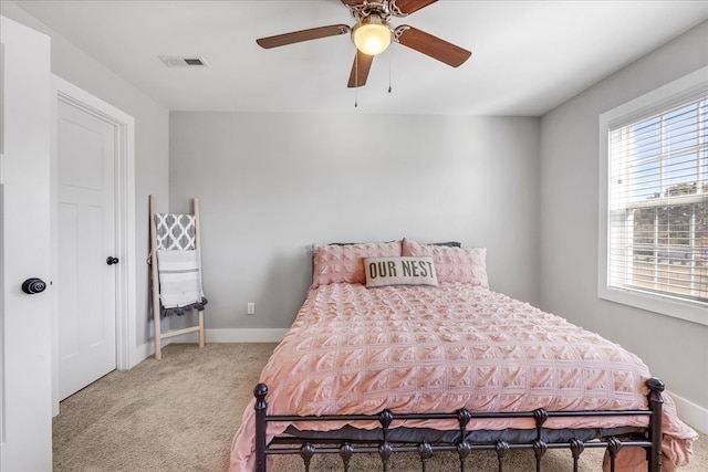 carpeted bedroom with multiple windows and ceiling fan