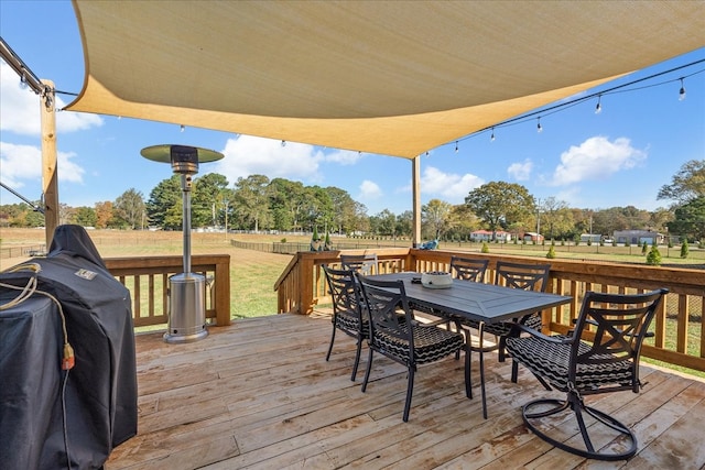 wooden terrace with a lawn and a grill