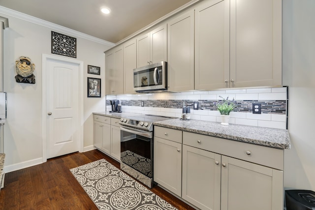 kitchen featuring appliances with stainless steel finishes, backsplash, dark wood-type flooring, light stone counters, and ornamental molding