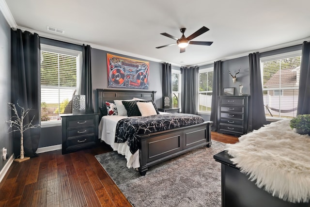 bedroom with ornamental molding, dark hardwood / wood-style floors, and ceiling fan