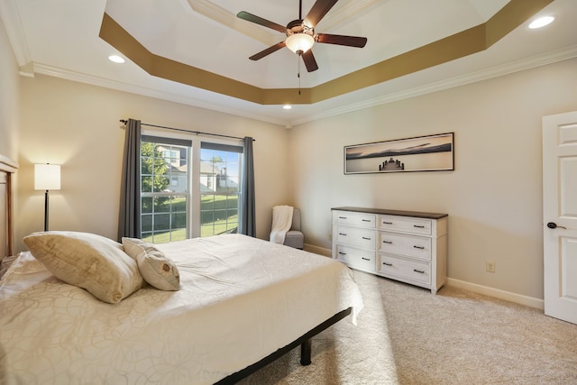 bedroom featuring crown molding, light carpet, a tray ceiling, and ceiling fan