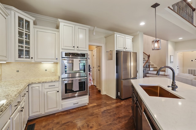 kitchen featuring appliances with stainless steel finishes, white cabinets, sink, and dark hardwood / wood-style flooring