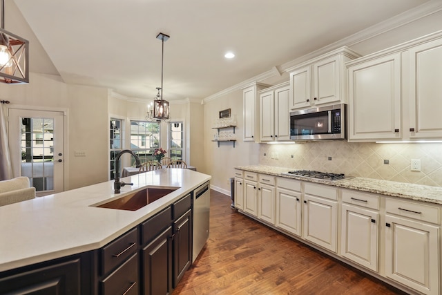 kitchen featuring dark hardwood / wood-style flooring, appliances with stainless steel finishes, a chandelier, pendant lighting, and sink