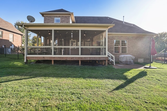 back of property featuring a patio, a lawn, and a sunroom