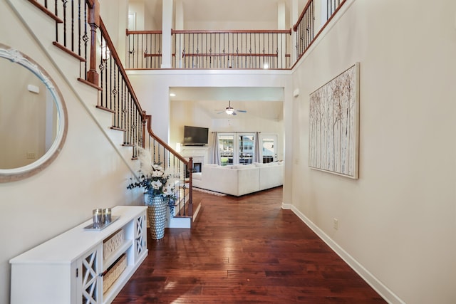 entryway featuring ceiling fan, a towering ceiling, and dark hardwood / wood-style flooring