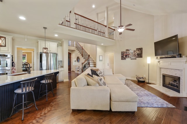 living room with sink, dark hardwood / wood-style floors, high vaulted ceiling, and ceiling fan