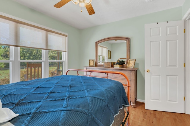 bedroom with ceiling fan, baseboards, and wood finished floors