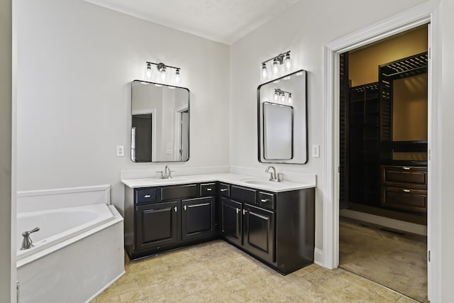 bathroom with vanity, a textured ceiling, and a bath