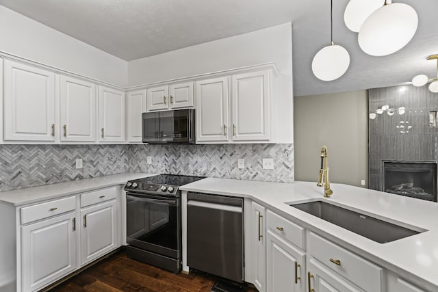 kitchen with sink, white cabinets, hanging light fixtures, and stainless steel appliances