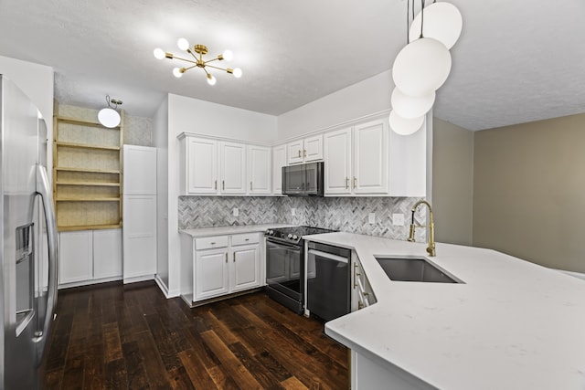 kitchen with white cabinets, appliances with stainless steel finishes, dark hardwood / wood-style floors, sink, and decorative light fixtures