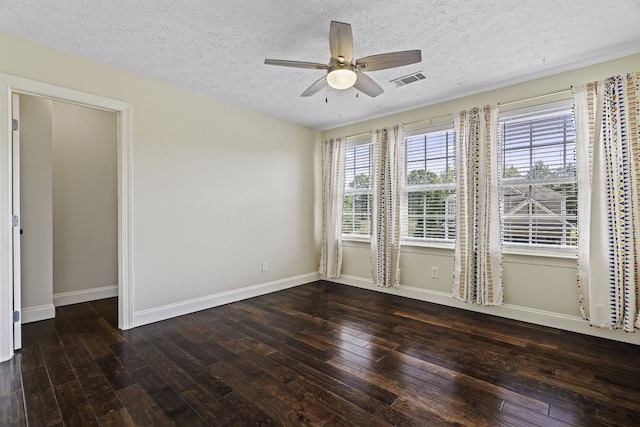 empty room featuring dark wood-type flooring, a textured ceiling, and ceiling fan