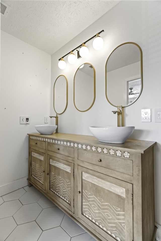 bathroom featuring vanity, a textured ceiling, and tile patterned flooring