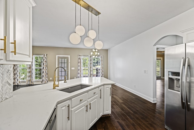 kitchen with white cabinetry, a healthy amount of sunlight, decorative light fixtures, and stainless steel refrigerator with ice dispenser