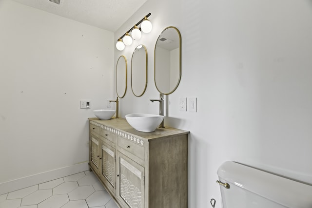 bathroom featuring vanity, a textured ceiling, and toilet