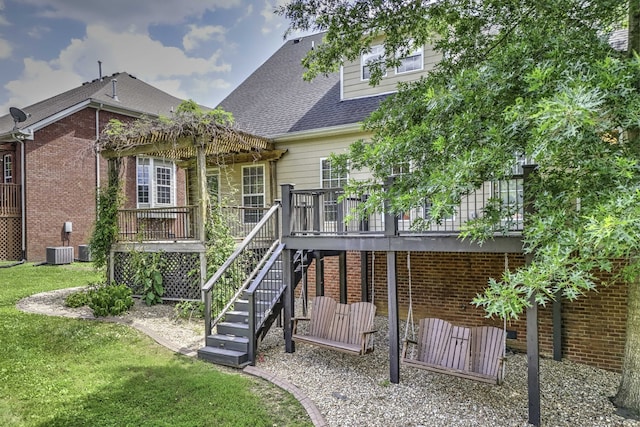 rear view of house featuring a wooden deck, a lawn, and central air condition unit