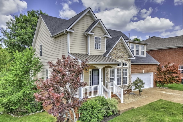 view of front facade with a front yard, a porch, and a garage