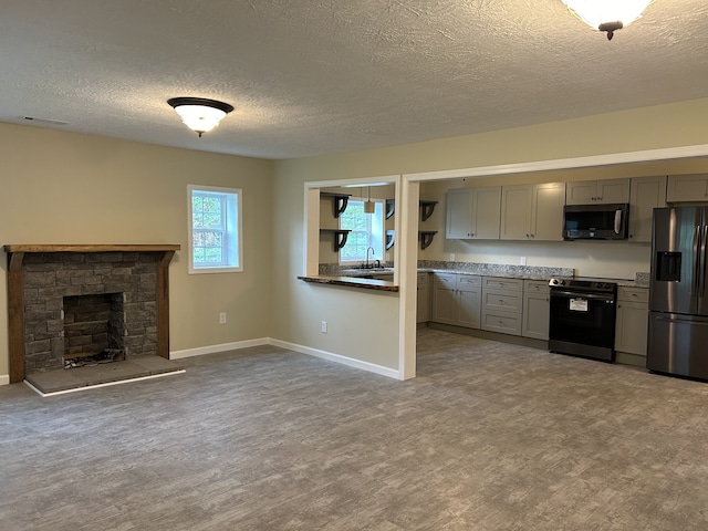 kitchen featuring stainless steel fridge, black electric range, a fireplace, and gray cabinetry