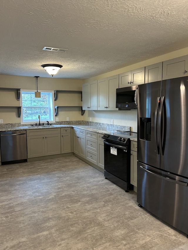 kitchen with gray cabinetry, stainless steel appliances, sink, pendant lighting, and a textured ceiling