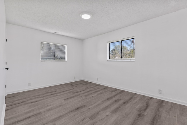 spare room featuring a textured ceiling and light wood-type flooring