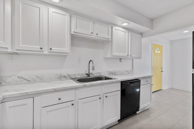 kitchen with dishwasher, sink, light stone countertops, light tile patterned floors, and white cabinets