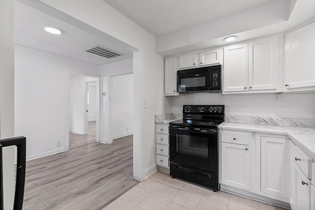 kitchen featuring white cabinetry, black appliances, light wood-type flooring, and a textured ceiling