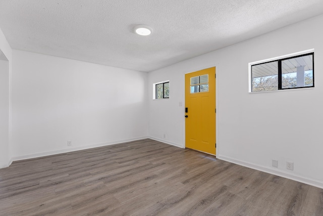 unfurnished room with a textured ceiling and hardwood / wood-style flooring