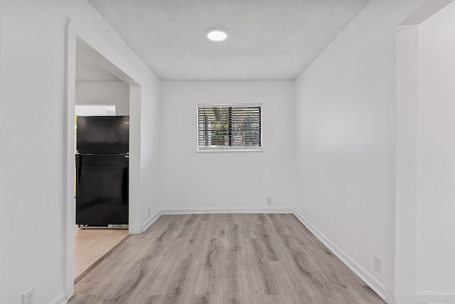 empty room featuring light hardwood / wood-style floors and a textured ceiling