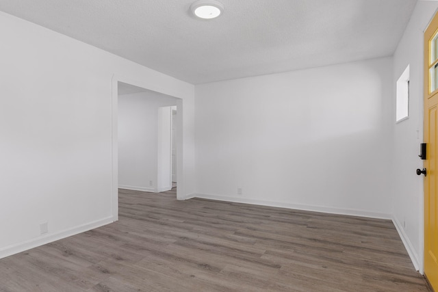 empty room with hardwood / wood-style flooring and a textured ceiling