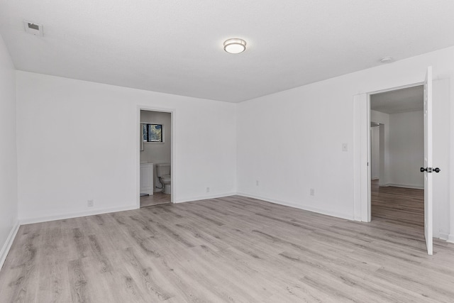 empty room featuring light hardwood / wood-style floors and a textured ceiling