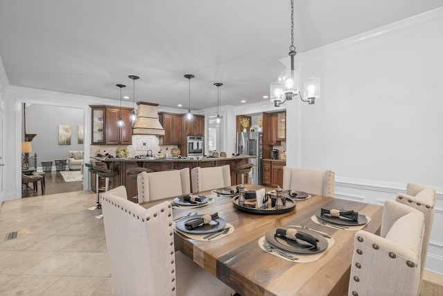 tiled dining room with ornamental molding and an inviting chandelier