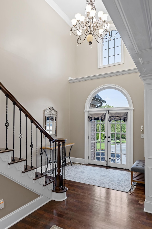 foyer with french doors, a towering ceiling, dark hardwood / wood-style flooring, and plenty of natural light