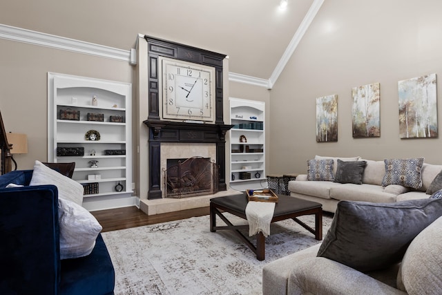 living room with vaulted ceiling, ornamental molding, dark wood-type flooring, built in features, and a fireplace