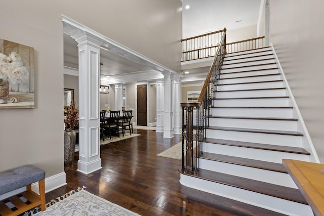 entrance foyer with crown molding, dark hardwood / wood-style floors, and decorative columns