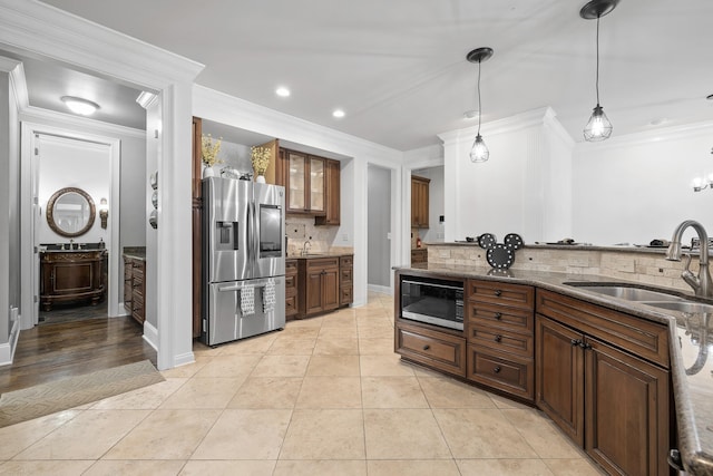 kitchen with ornamental molding, sink, stainless steel appliances, and tasteful backsplash