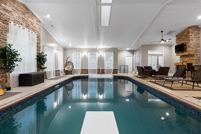 view of swimming pool featuring ceiling fan and a diving board