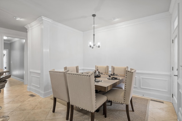 tiled dining room featuring an inviting chandelier and ornamental molding