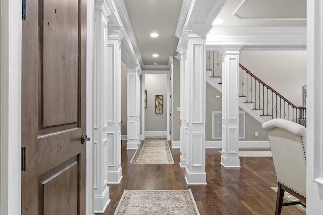 foyer with crown molding, dark hardwood / wood-style floors, and ornate columns