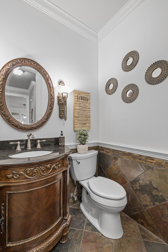 bathroom featuring vanity, tile walls, ornamental molding, and toilet