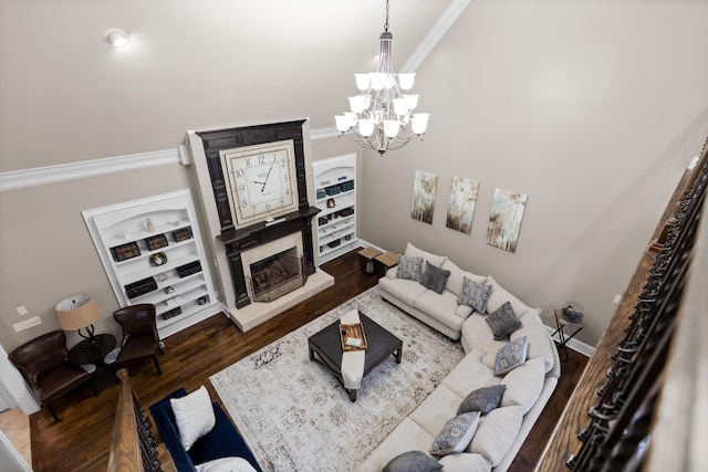 living room with dark wood-type flooring, crown molding, and an inviting chandelier