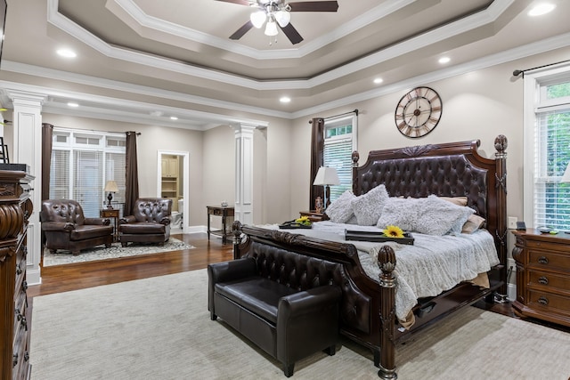 bedroom featuring ornamental molding, decorative columns, and hardwood / wood-style flooring