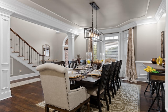 dining area with crown molding, a chandelier, dark wood-type flooring, and decorative columns