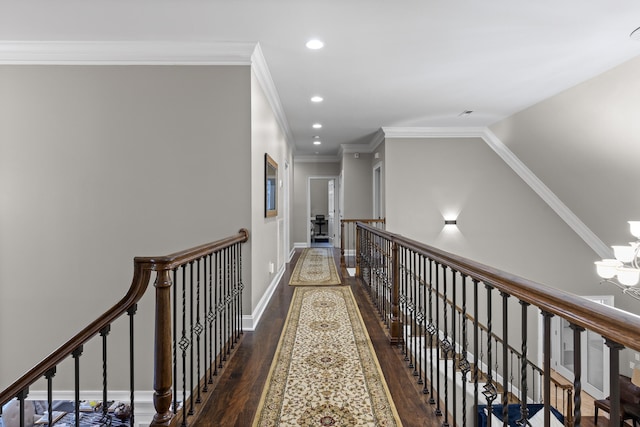 hall featuring dark wood-type flooring, a notable chandelier, and crown molding