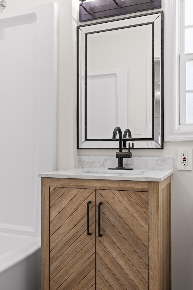 bathroom featuring vanity and a tub