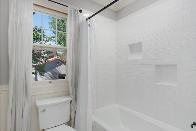 bathroom featuring toilet, crown molding, and shower / bath combo